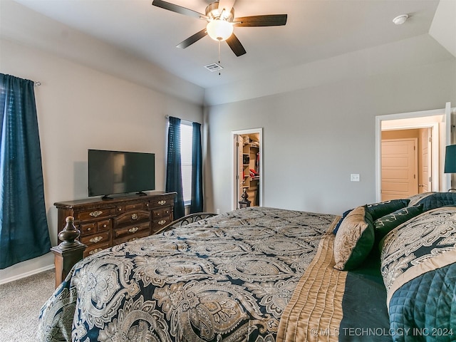 bedroom featuring visible vents, vaulted ceiling, a spacious closet, and carpet flooring