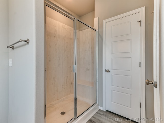 bathroom featuring an enclosed shower and hardwood / wood-style flooring