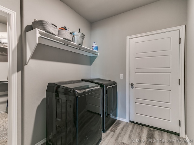 laundry area with separate washer and dryer and light wood-type flooring