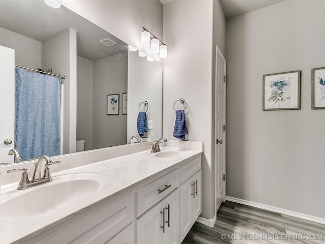 full bathroom featuring visible vents, a sink, baseboards, and wood finished floors