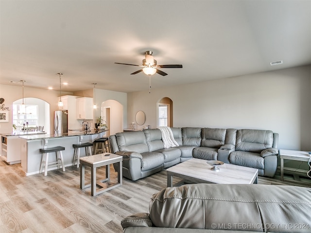 living room with light wood-type flooring and ceiling fan