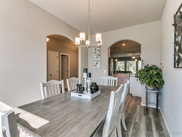 dining room with ceiling fan with notable chandelier, wood-type flooring, and sink