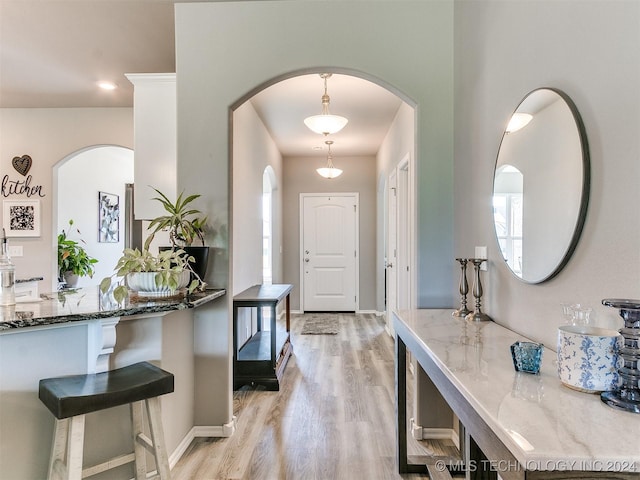 foyer entrance with light wood-style flooring and baseboards