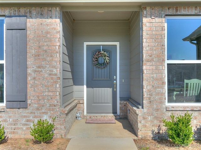 doorway to property featuring brick siding