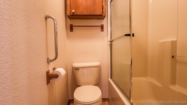 bathroom with shower / bath combination with glass door and toilet