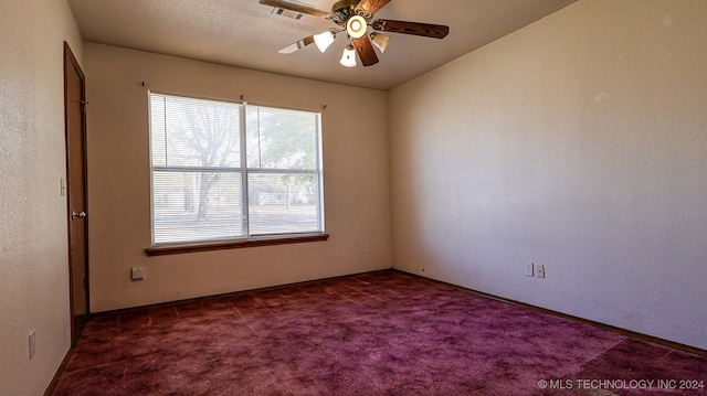 carpeted empty room with ceiling fan and a textured ceiling