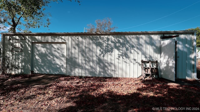 view of side of property featuring a garage and an outbuilding