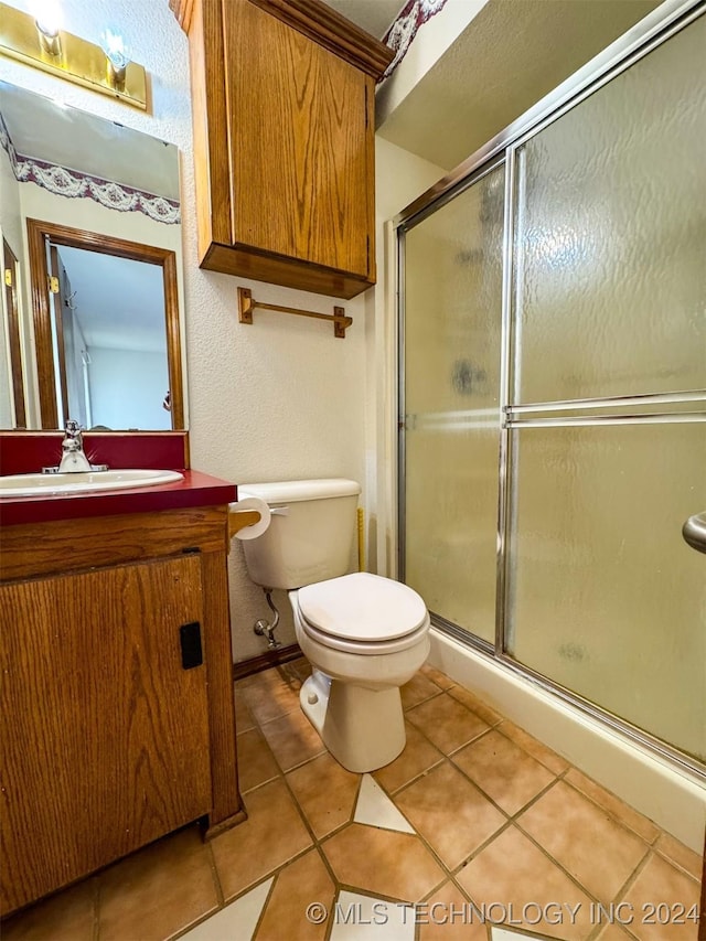 bathroom featuring vanity, an enclosed shower, and tile patterned flooring