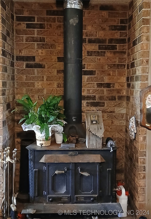 bar featuring a wood stove and brick wall