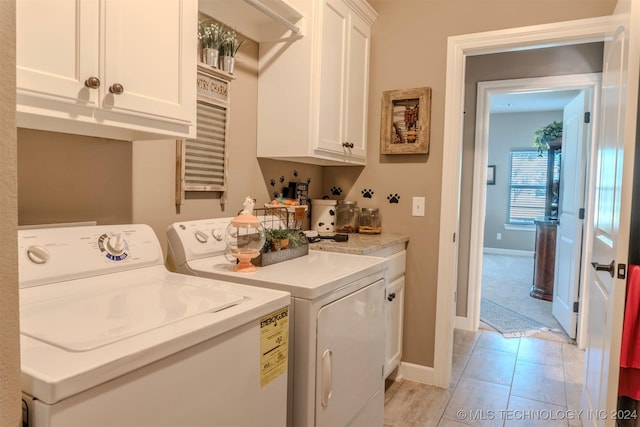 laundry area featuring cabinets and washer and clothes dryer