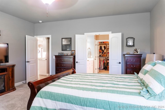 carpeted bedroom featuring a walk in closet, connected bathroom, and a closet