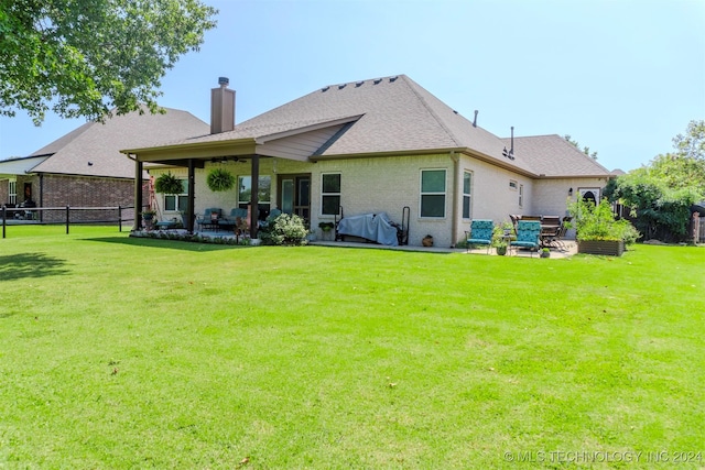 back of house with a lawn and a patio