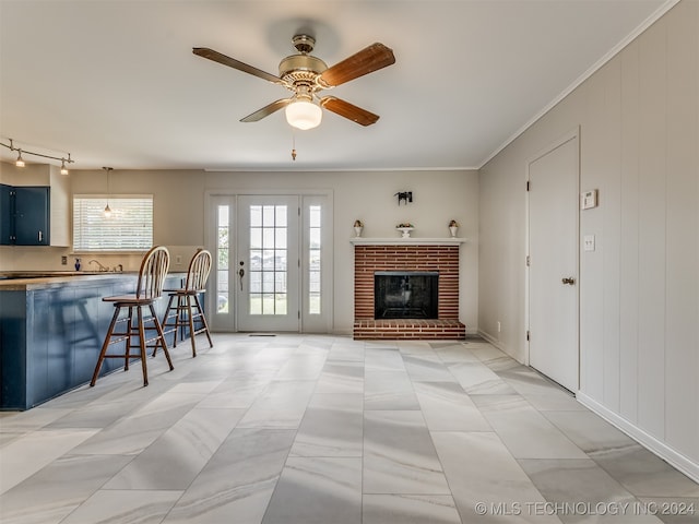 living room with a fireplace, ceiling fan, and ornamental molding