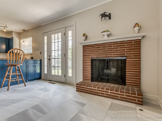 living room with tile patterned floors, ornamental molding, and a brick fireplace