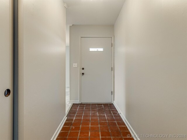 doorway with dark tile patterned flooring