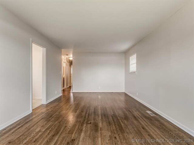 spare room with dark hardwood / wood-style floors