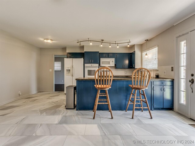 kitchen featuring a kitchen breakfast bar, white appliances, blue cabinets, and kitchen peninsula