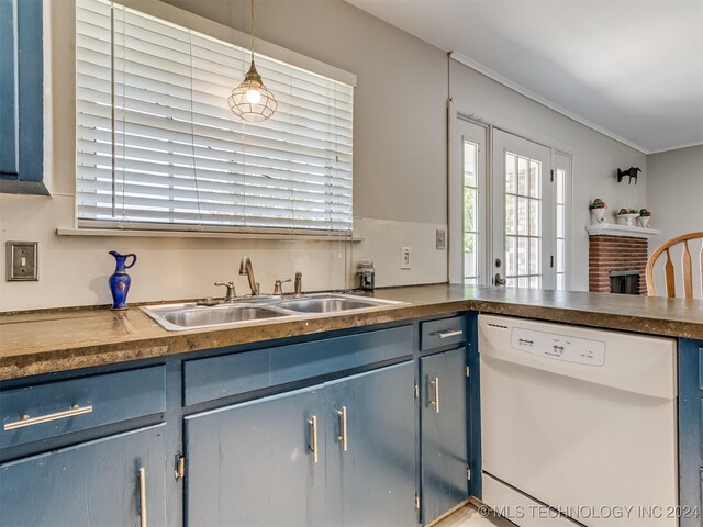 kitchen with a brick fireplace, white dishwasher, blue cabinets, sink, and hanging light fixtures