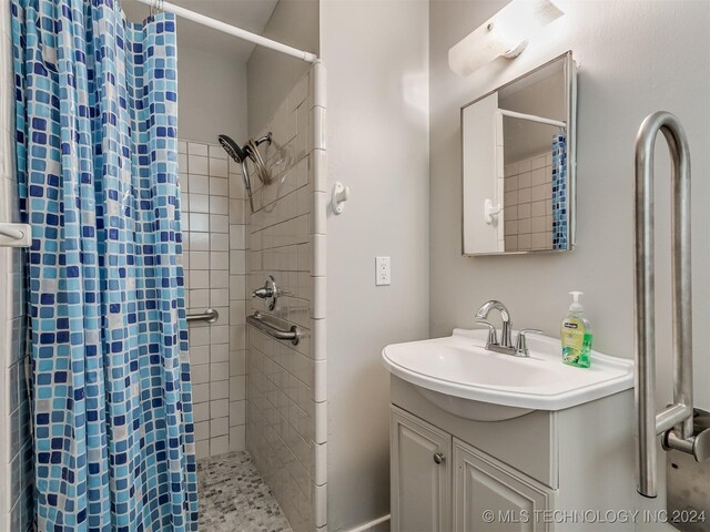 bathroom with curtained shower and vanity