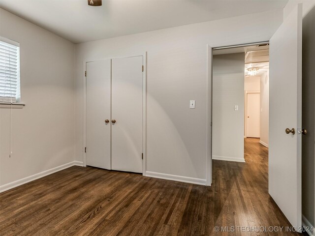 unfurnished bedroom with dark wood-type flooring