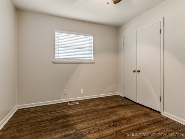 unfurnished bedroom with a closet, ceiling fan, and dark hardwood / wood-style flooring