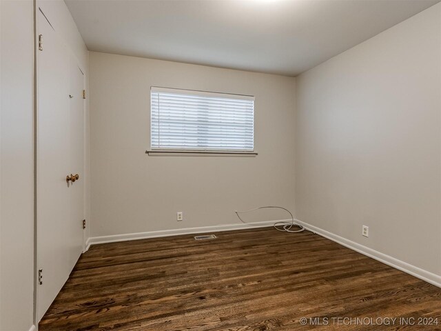 unfurnished room with dark hardwood / wood-style floors