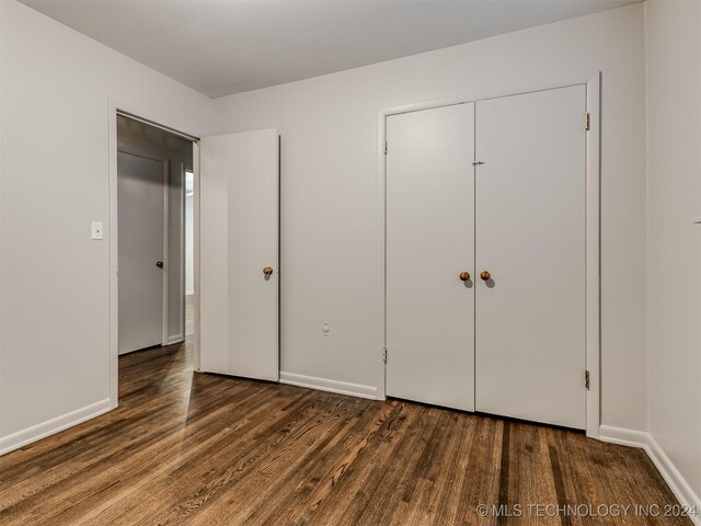 unfurnished bedroom with dark wood-type flooring