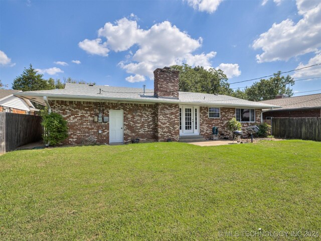 back of property featuring a yard and a patio