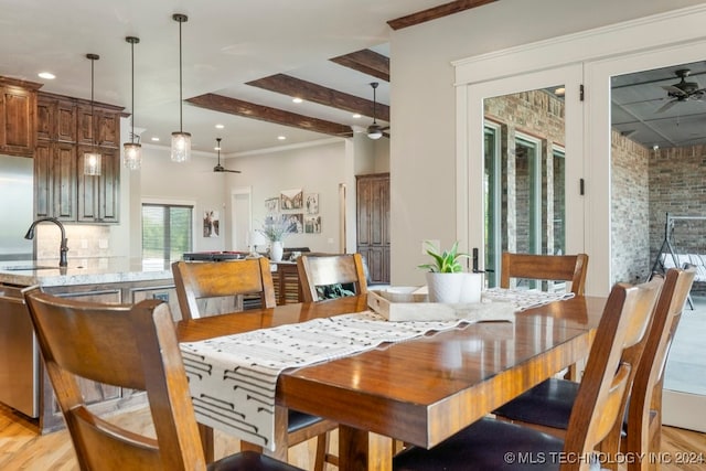 dining area featuring light hardwood / wood-style flooring, ceiling fan, sink, and beamed ceiling