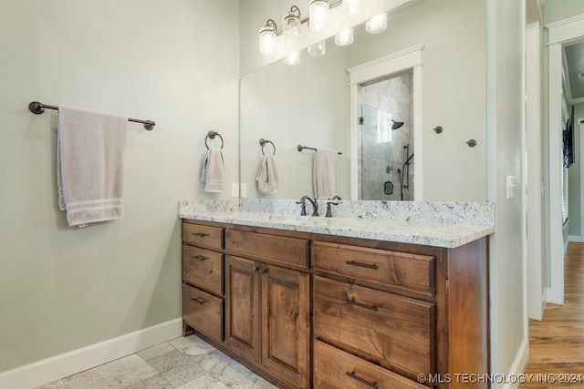 bathroom featuring a shower with shower door and vanity