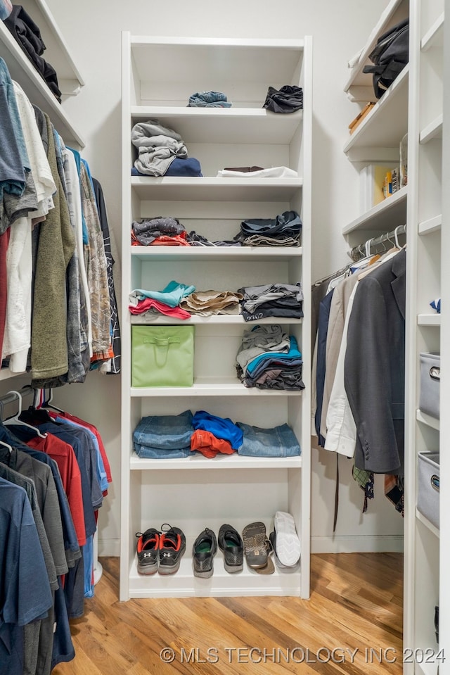 walk in closet with light hardwood / wood-style floors