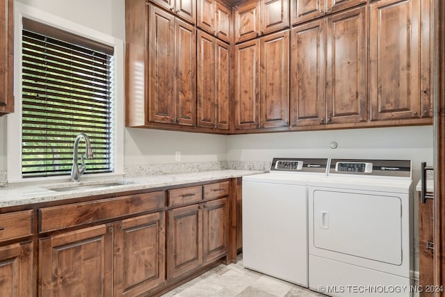 laundry area with washer and dryer, cabinets, and sink