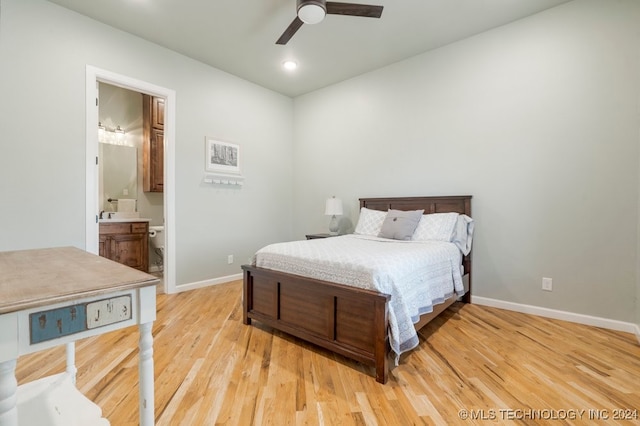 bedroom featuring light hardwood / wood-style floors, ensuite bathroom, and ceiling fan