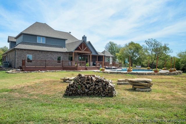 rear view of house with a pool side deck, a lawn, and cooling unit