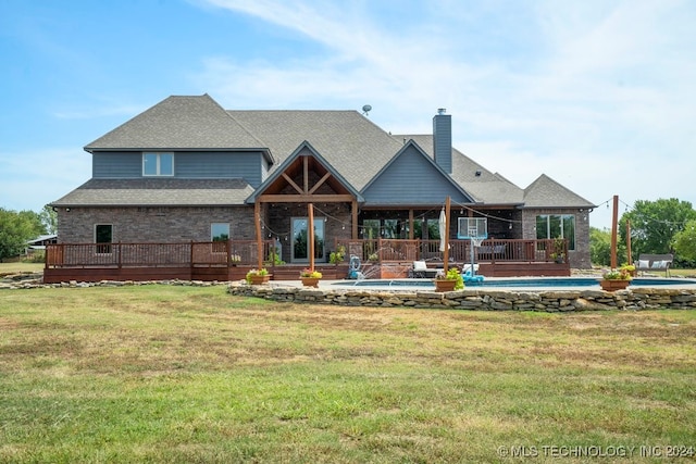 back of house featuring a swimming pool side deck and a lawn