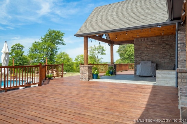 wooden deck with a pool and a gazebo