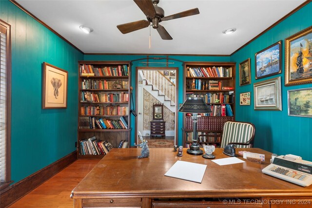 office space featuring light wood-type flooring, ceiling fan, crown molding, and built in features