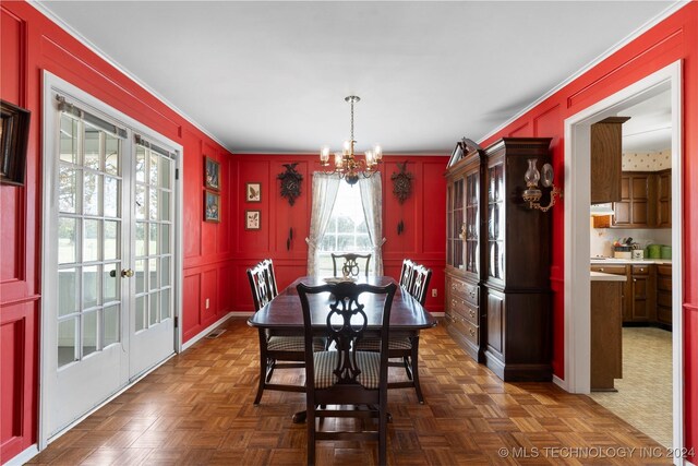 dining space featuring an inviting chandelier and dark parquet flooring