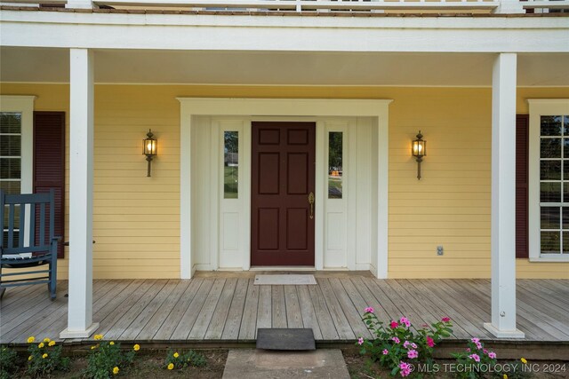 view of exterior entry featuring covered porch