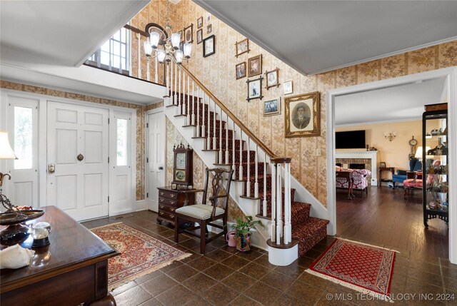 entryway with ornamental molding, a fireplace, plenty of natural light, and dark hardwood / wood-style flooring