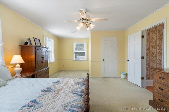 carpeted bedroom featuring ceiling fan and ornamental molding