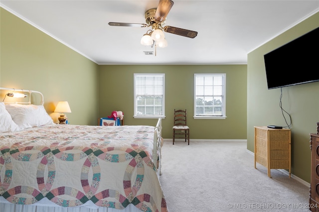 carpeted bedroom featuring crown molding and ceiling fan