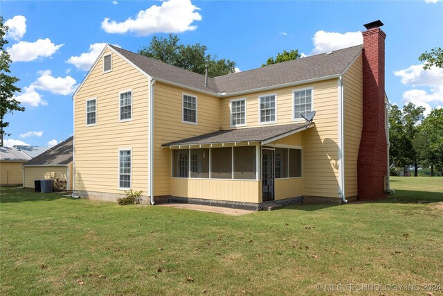 back of property with cooling unit, a sunroom, and a yard