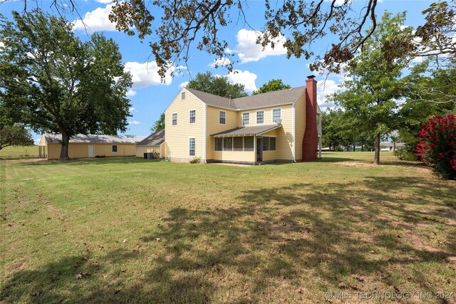 rear view of house featuring a lawn