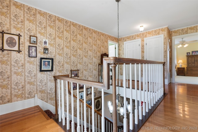 corridor with ornamental molding and hardwood / wood-style flooring