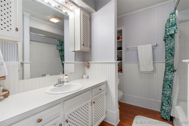 full bathroom with vanity, wood-type flooring, shower / bath combo, ornamental molding, and toilet