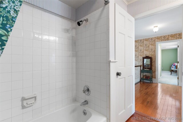 bathroom with tiled shower / bath combo and hardwood / wood-style flooring