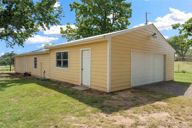 garage featuring a yard and wood walls