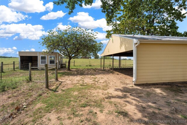 view of yard with an outbuilding and a rural view