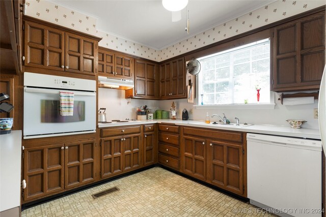 kitchen featuring ornamental molding, white appliances, ceiling fan, and sink